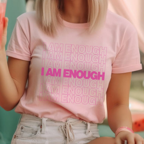 blonde girl wearing pink shirt with pink typography that says "I am Enough" 7 times line after line. Shirt is modeled after the Thank You plastic trash bags. The 4th "I am enough" is in bold font, while the remaining font is less drastic and outlined.